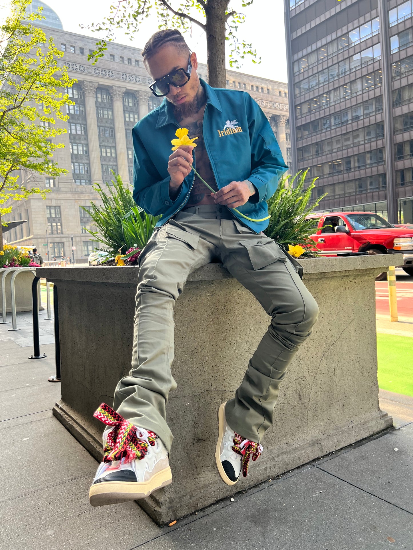 Seated model wearing Green Stacked Cargo Pants with an Iridium jacket