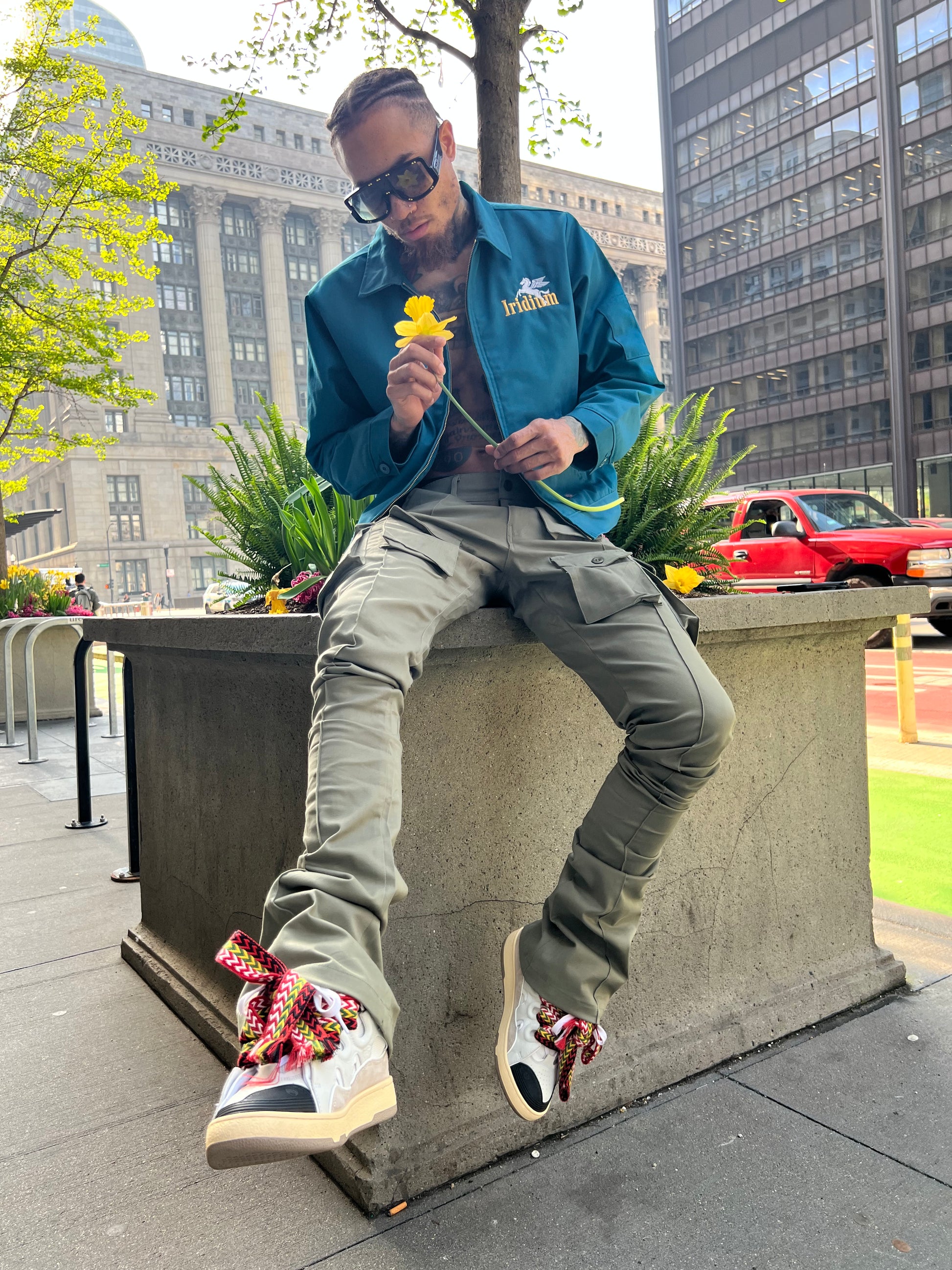 Seated model wearing Green Stacked Cargo Pants with an Iridium jacket
