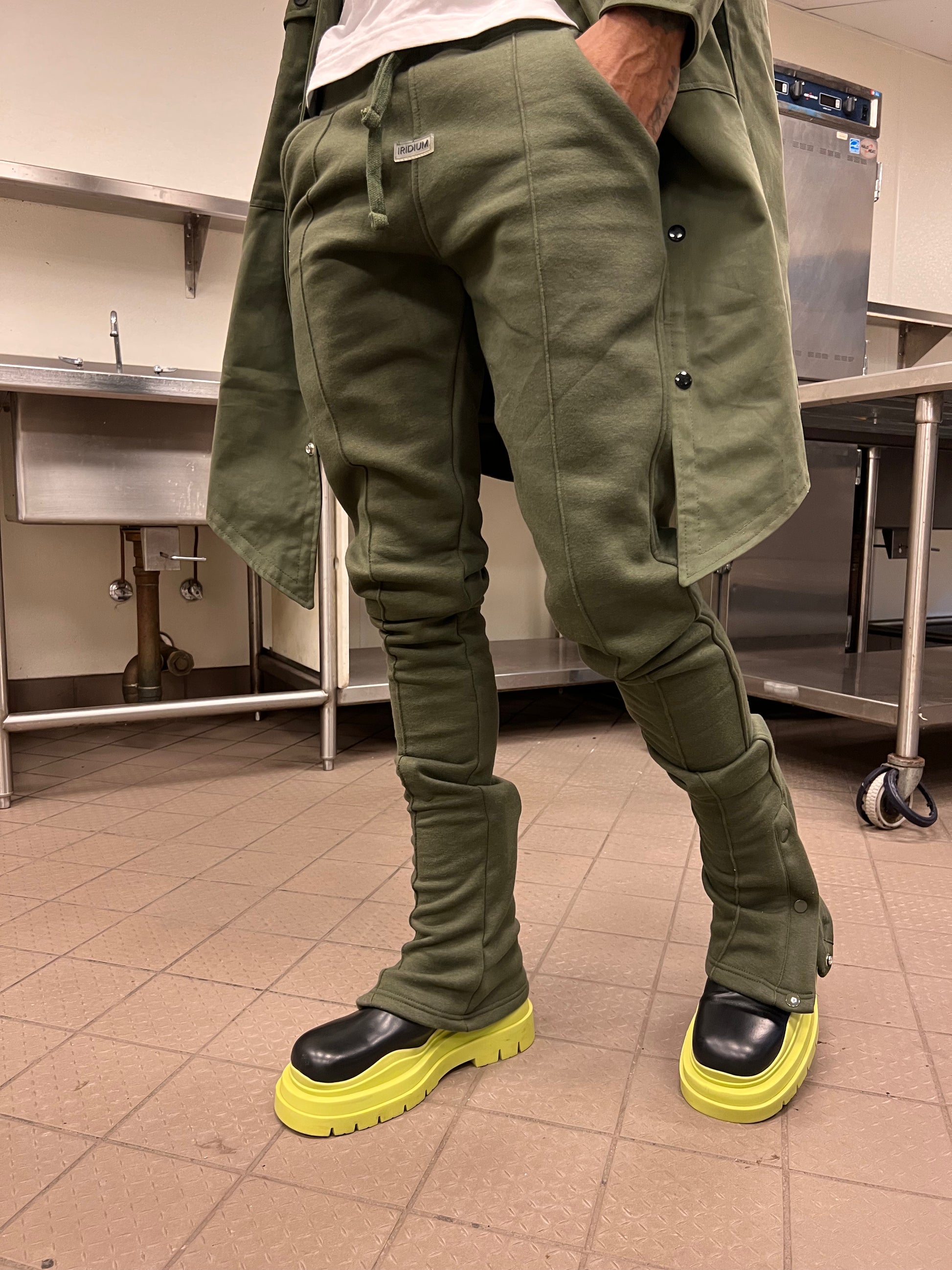 Model standing in Green Stacked Joggers with black and neon sneakers