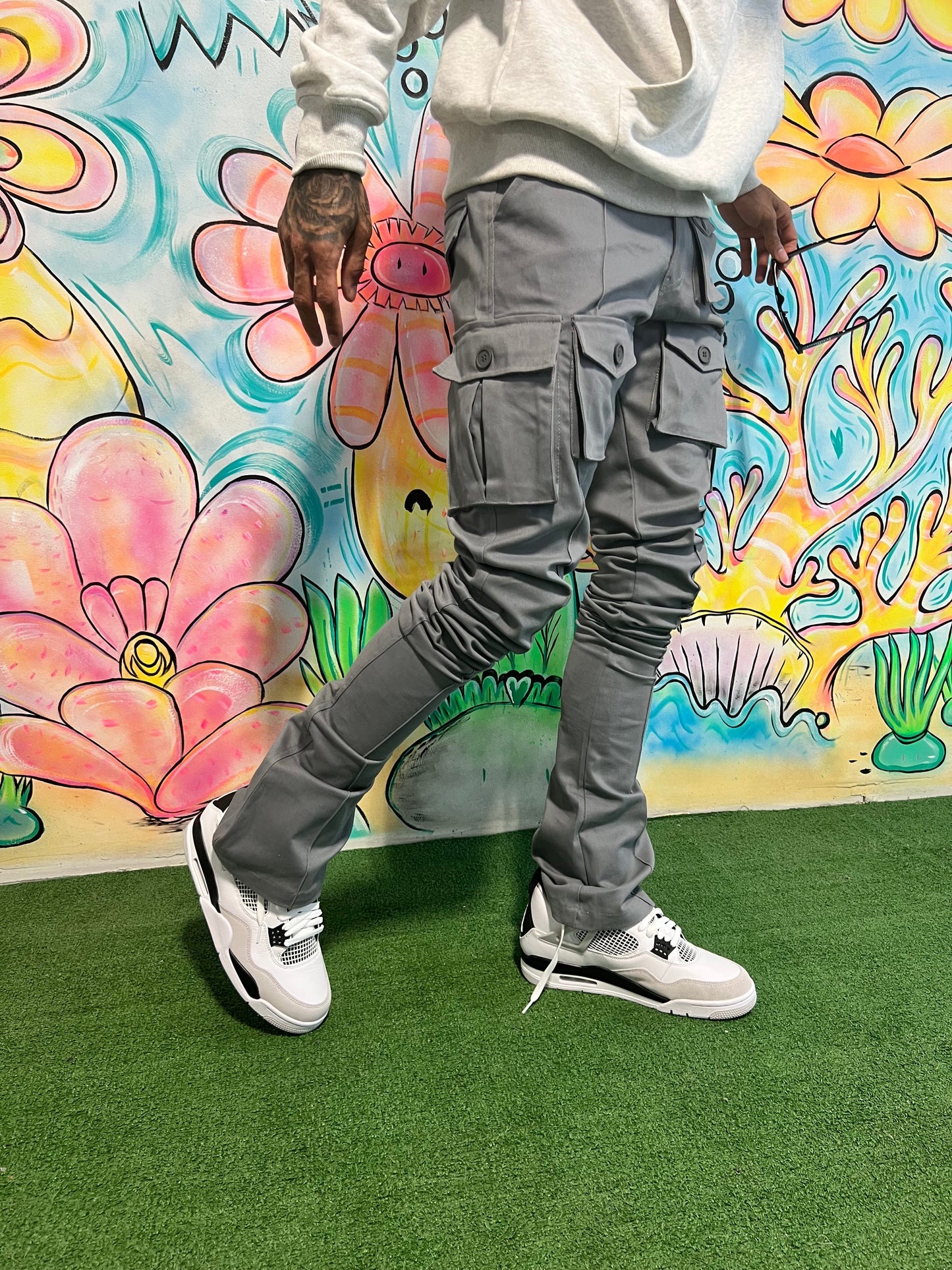 Model wearing Iridium Grey Stacked Cargo Pants in front of a colorful mural