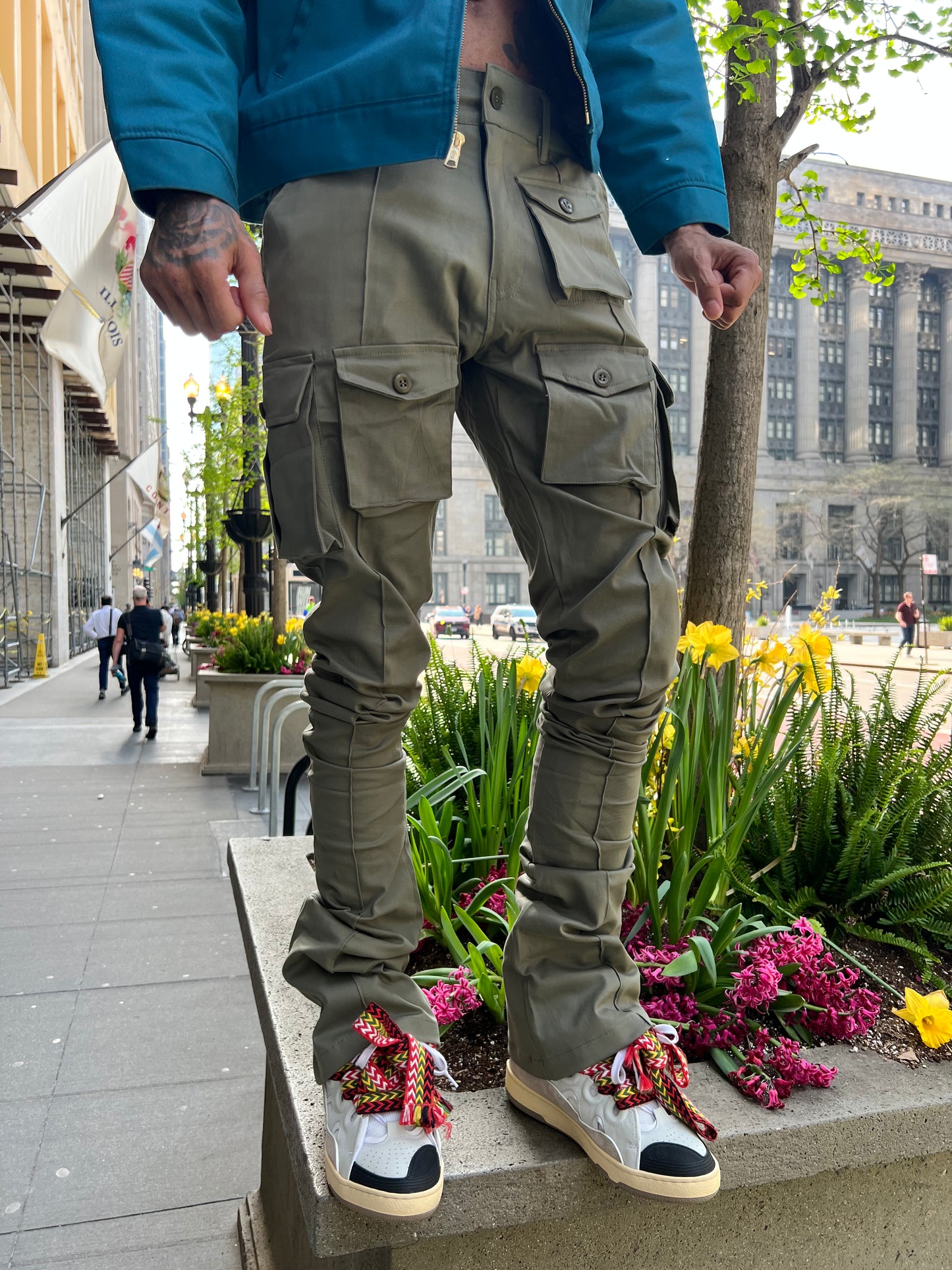 Front detail view of the waistband and cargo pockets on Green Stacked Cargo Pants